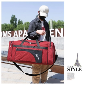 Outdoor shot of a red oxford travel bag with 'Sports' text and reinforced black handles