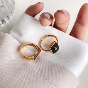 Detailed view of French-style gold rings with black square drip oil and D-letter design