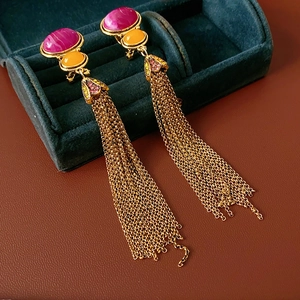 Detail of vintage gold tassel earrings with ruby red and orange oval gemstones in a box