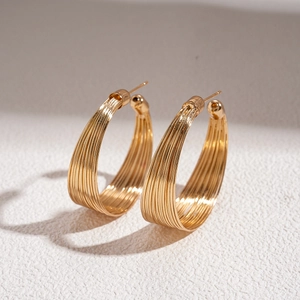 Detailed macro view of gold multi-layered C-shaped hoop earrings with polished finish