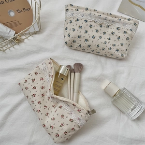 Detail of floral makeup bags with delicate white lace trim and secure metal zippers