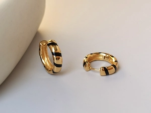 Detail view of gold S925 silver earrings with black striped enamel texture for women
