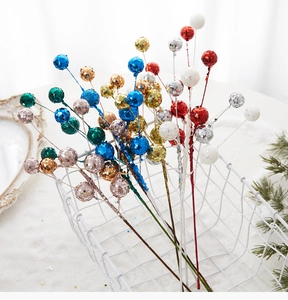 Nahaufnahme von glitzernden Dekozweigen in verschiedenen Farben für Weihnachtsdekoration