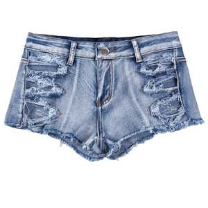 Dettaglio ravvicinato di pantaloncini di denim azzurro con strappi e orli con frange