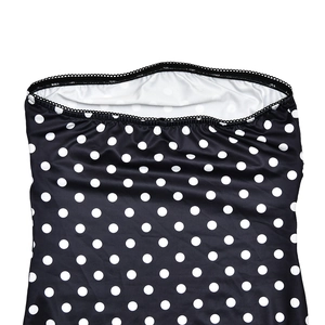 Detail of the black polka dot tube dress showing the elastic neckline and smooth fabric texture