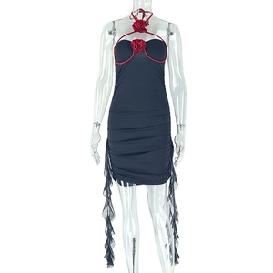 Détail de la rose rouge au cou et des volants transparents sur robe courte moulante