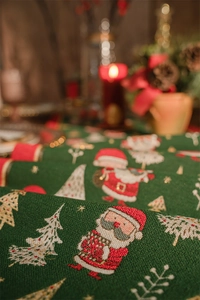 Close-up of green Christmas table runner with embroidered Santa Claus and festive trees