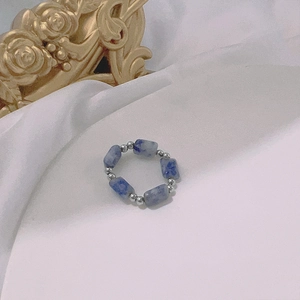 Detailed shot of handmade elastic bead ring with blue natural stones and silver spacers