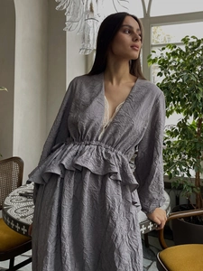 Détail du décolleté en V avec dentelle et texture plissée sur la robe mauve