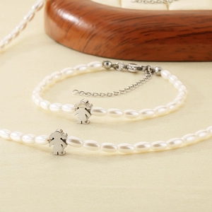 Detail of beaded necklace and bracelet set with silver girls pendants and freshwater pearls