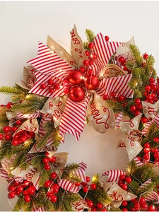 Macro detail of 50cm Christmas wreath with berries, ribbons and warm LED light string