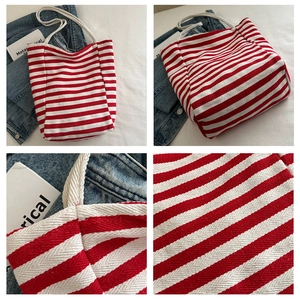 Detail view of red and white striped canvas tote bag with cotton rope handles