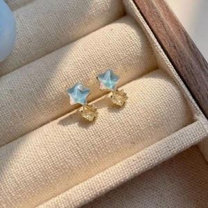 Macro detail of star-shaped earrings with blue resin and yellow zircon in jewelry box