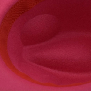 Close-up of the inner felt texture and grosgrain sweatband of the rose pink wool fedora