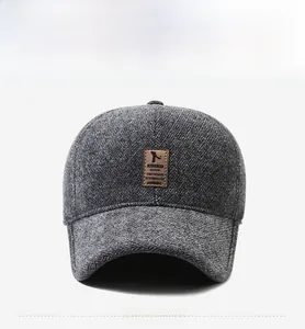 Detailed view of grey herringbone pattern texture and brown leather patch on the cap