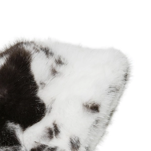 Close-up of soft black and white cow print faux fox fur texture on a winter hat