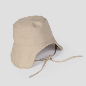 Macro view showing the durable beige canvas texture and windproof strap of the sun hat
