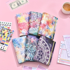 Flat lay of A6 PU leather budget binders with mandala patterns and savings stickers