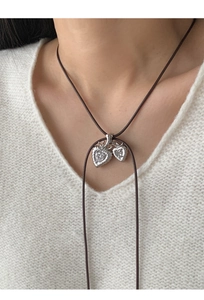 Close-up of double heart pendant with cubic zirconia on brown wax cord necklace