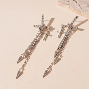Detail of silver cross tassel earrings with sparkling rhinestones and cone pendants