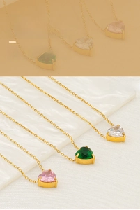 Detailed view of heart-shaped zircon necklaces in pink, green and clear on a white tray