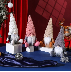 Close-up of four plush Nordic Christmas gnomes in white, pink, khaki, and grey colors