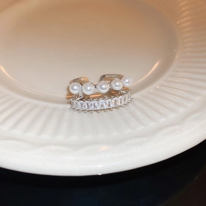 Vue macro d'une bague double en argent avec perles blanches et zircons rectangulaires