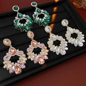 Détails de trois paires de boucles d'oreilles géométriques de luxe avec strass colorés