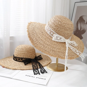 Sommer Raffia Sonnenhüte mit eleganten Spitzenbändern und Fransenrand auf einem Displayständer