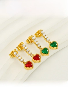 Detail view of titanium steel pearl earrings with red and green heart-shaped gemstones