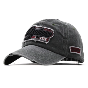 Macro detail of charcoal grey vintage baseball cap with distressed brim and 3D embroidery
