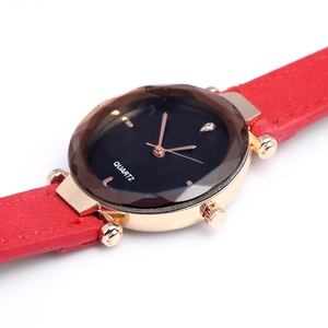 Detail view of quartz watch featuring red textured strap and rose gold case