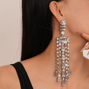 Gros plan de boucles d'oreilles à franges argentées avec cristaux sur un mannequin