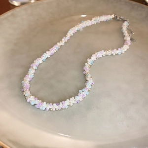 Détail d'un collier de perles tissé à la main sur une assiette avec chaîne d'extension