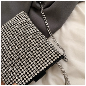 Close-up of sparkling silver rhinestones and delicate metal chain on the fashion shoulder bag