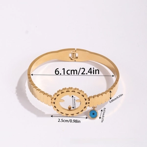Detailed top view of a gold titanium bangle with blue evil eye pendant and gear charm
