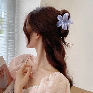 Detailed view of a matte translucent lavender flower hair claw clip on a model