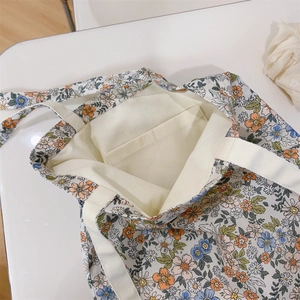 Dettaglio dell'interno della borsa in tela con tasca interna e motivi floreali piccoli