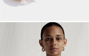 Close-up model shot of stylish chunky gold hoop earrings with a polished metal finish
