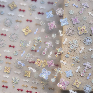 Macro detail of holographic floral nail stickers on stone showing fine metallic texture