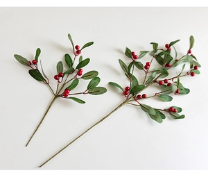 Close-up of artificial red berry stems with green pine leaves for Christmas decor