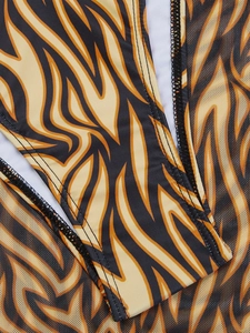 Detail of tiger print bikini fabric featuring mesh patchwork and fine stitching seams