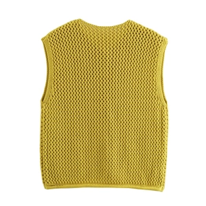 Dettaglio del gilet in maglia giallo senape con trama a maglia traforata in evidenza
