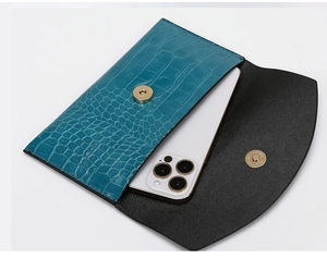 Detail of teal faux-crocodile texture flap bag showing capacity with a smartphone