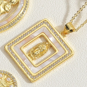 Macro shot of gold square pendant with mother of pearl Virgin Mary and zircon border