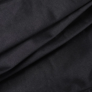 Dettaglio macro del tessuto a maglia nero che mostra la trama fine e il drappeggio