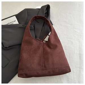 Flat lay of a brown faux suede Hobo shoulder bag paired with a gray blazer