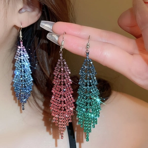 Detail of long feather tassel earrings with sparkling rhinestones in three vibrant colors