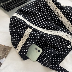 Detailed view of polka dot canvas tote with delicate white lace trim and daily essentials