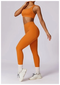 Side view of orange quick-dry yoga set showing racerback sports bra and high waist leggings